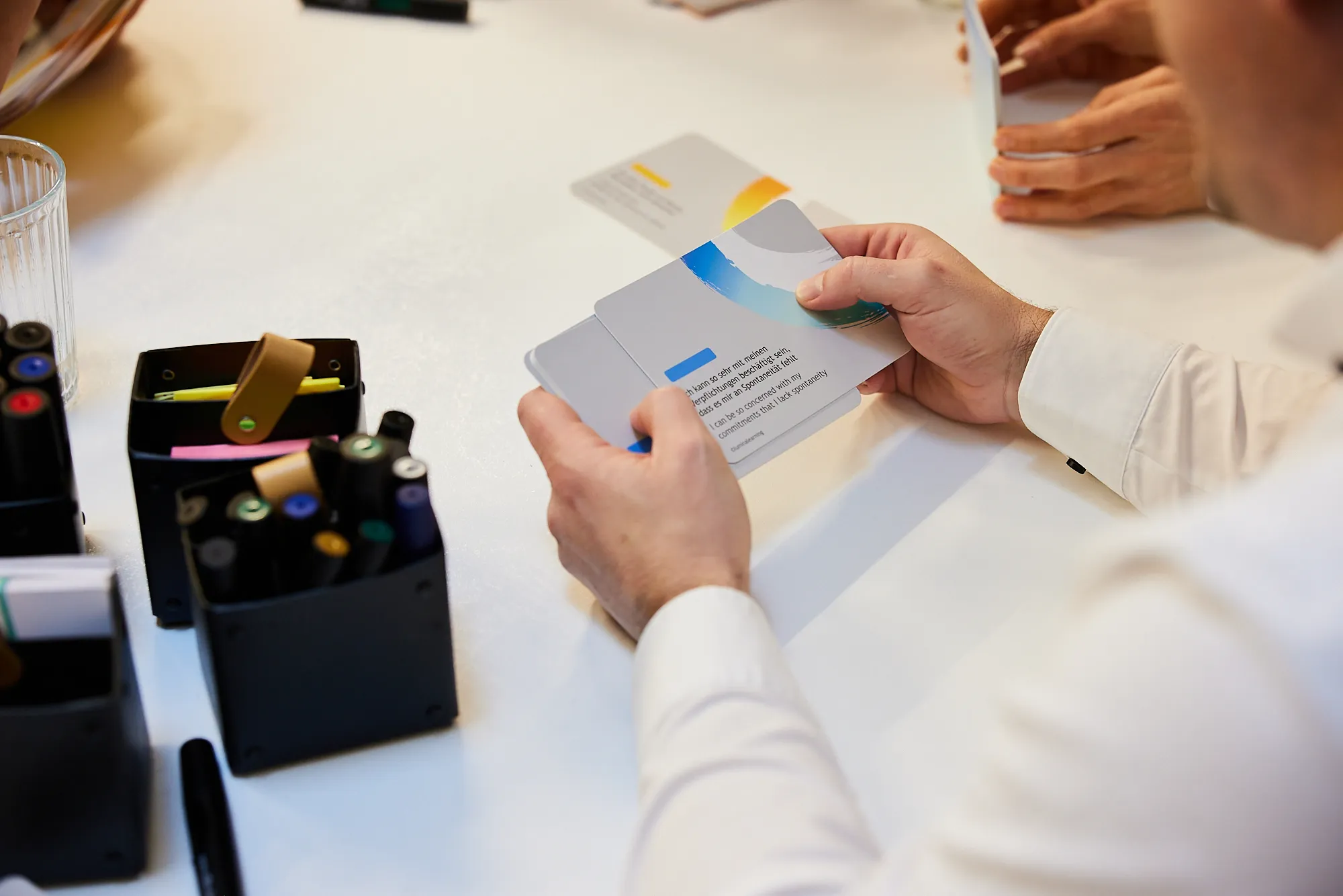 Mitarbeiter liest Karte und löst Aufgabe im Rahmen der Change Agent Ausbildung