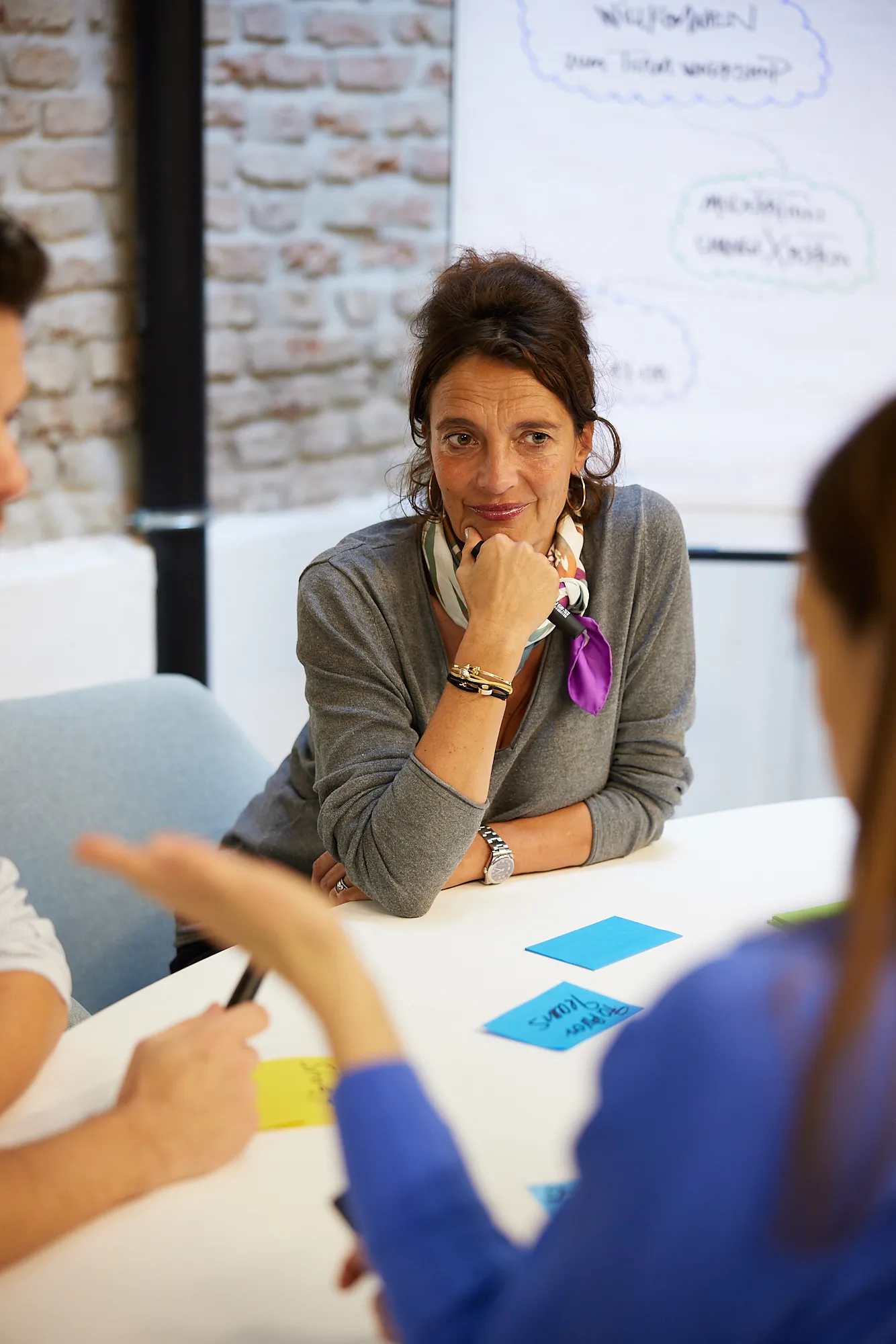 Workshopleiterin hört konzentriert zu, während Teilnehmerin im Change Management Workshop spricht