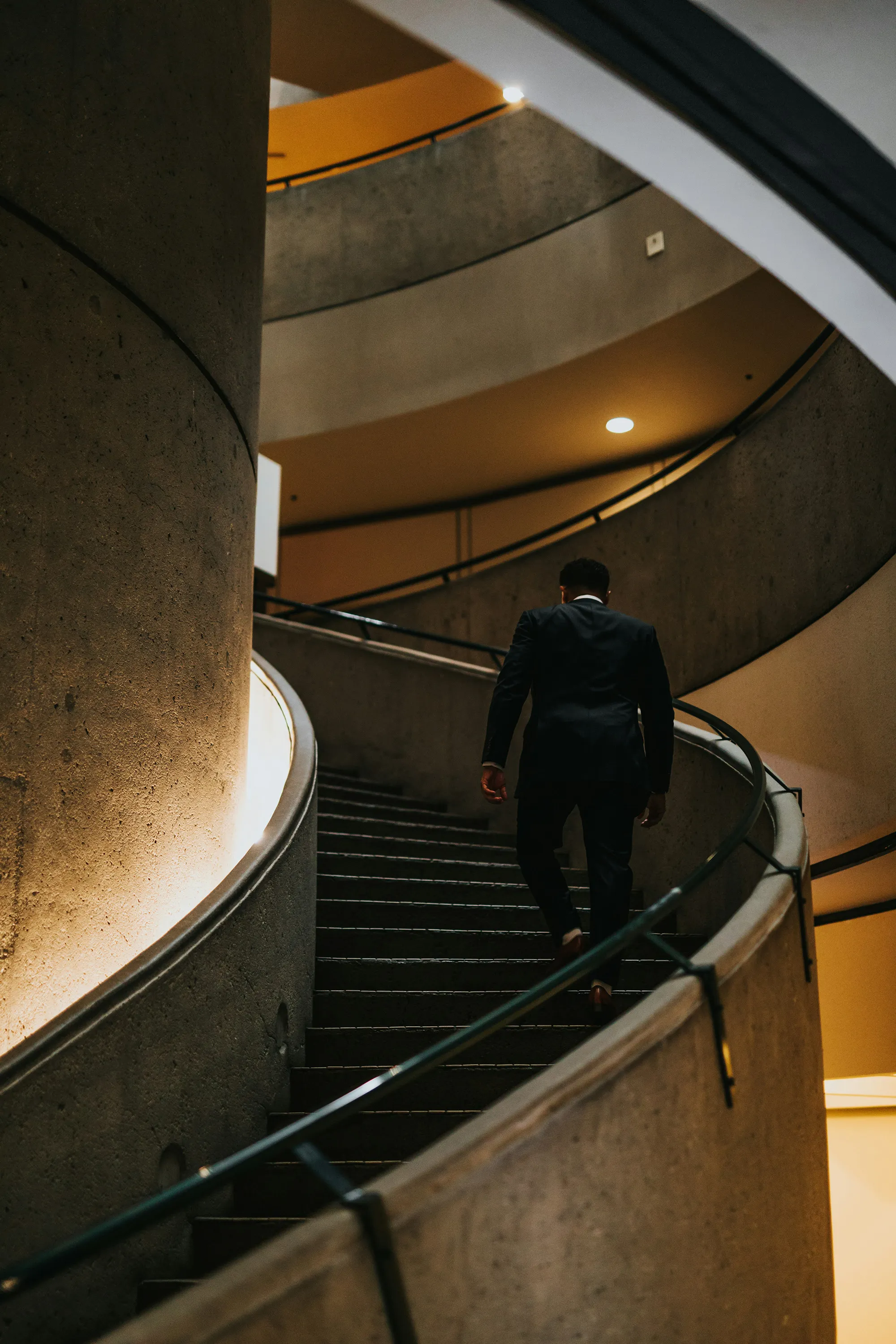 Eine Führungskraft läuft die Treppe hoch – Symbol für einsame Führungskraft ohne gelebte Unternehmenskultur