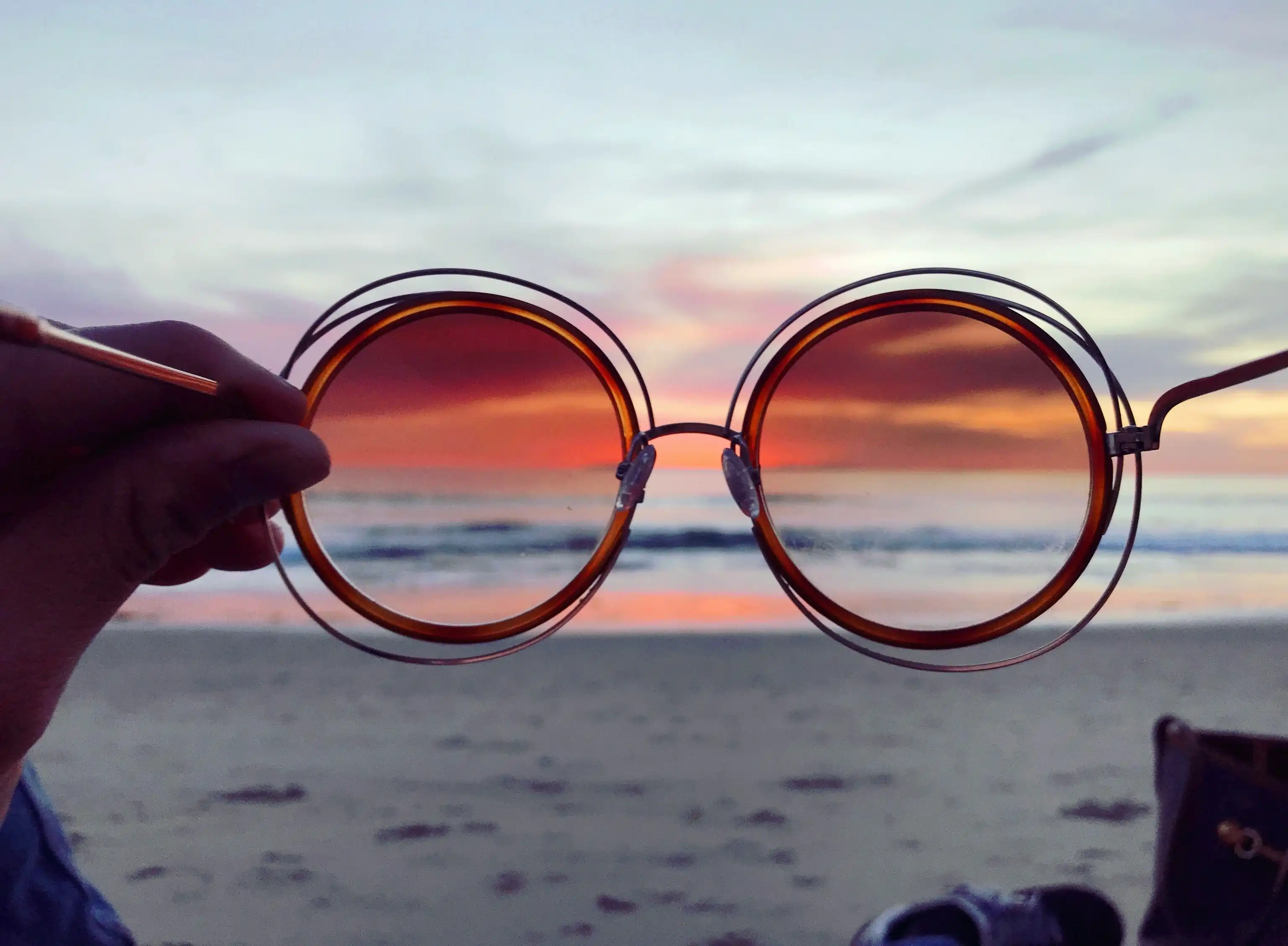 Sonnenbrille zeigt den Ozean durch einen Filter als Symbol für Perspektivwechsel